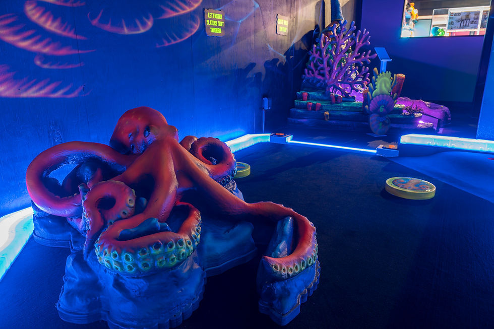 Octopus statue on glowing ocean-themed mini golf course