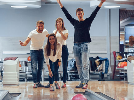 a group of people having fun bowling at king's entertainment