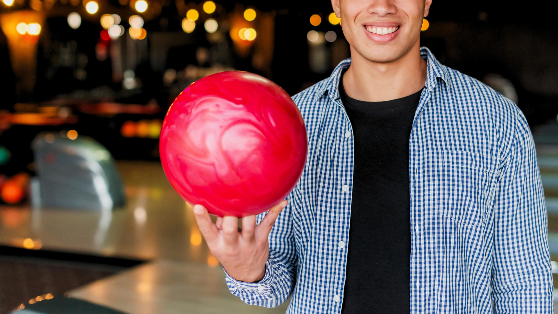 man holding bowling ball at kings entertainment