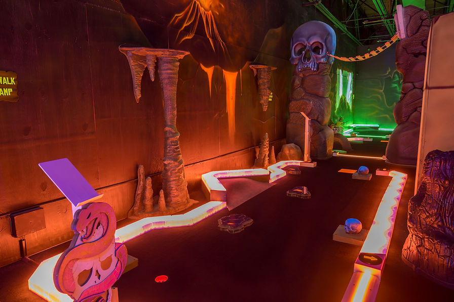 Glow-in-the-dark mini golf course at King’s Entertainment in Norfolk, NE featuring themed obstacles and immersive lighting