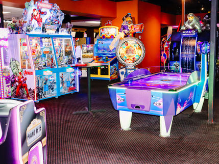 Families enjoying bowling, arcade games, and mini golf indoors at King's Entertainment in Norfolk, Nebraska.