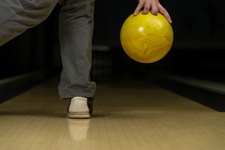 Person holding a yellow bowling ball at King’s Entertainment in Norfolk