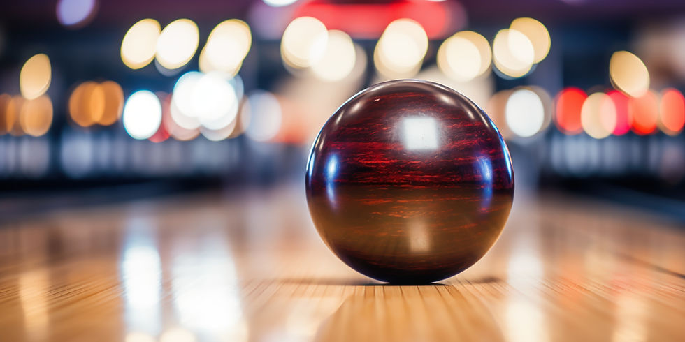 Bowling ball on polished lane with colorful bokeh lights in background at King’s Entertainment